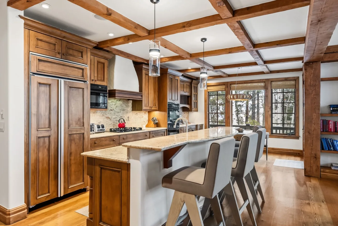 A spacious kitchen with a long island and several bar stools.