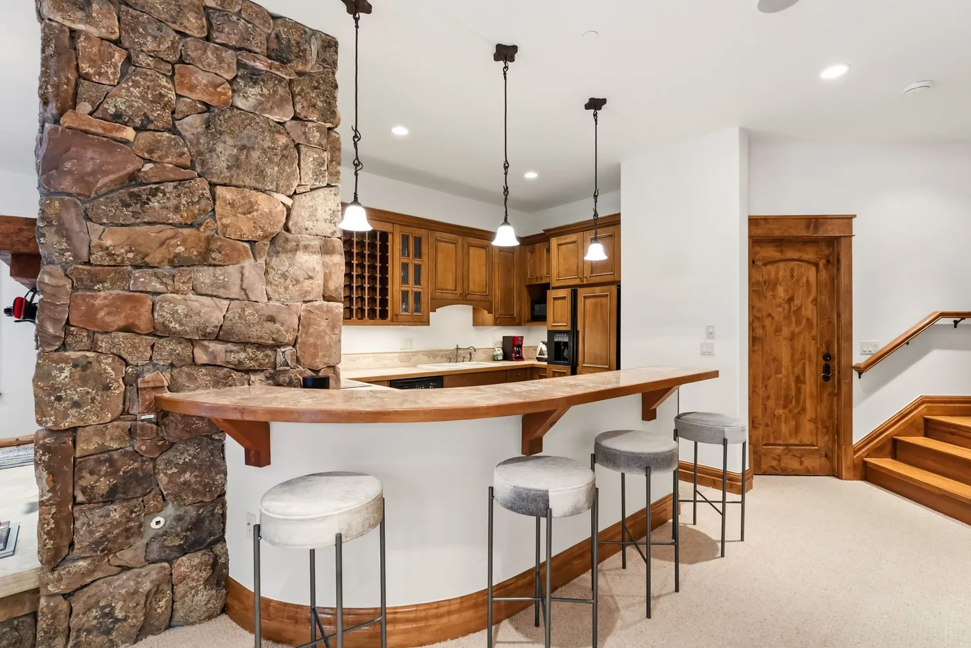 A kitchen with a curved counter and wooden cabinets.