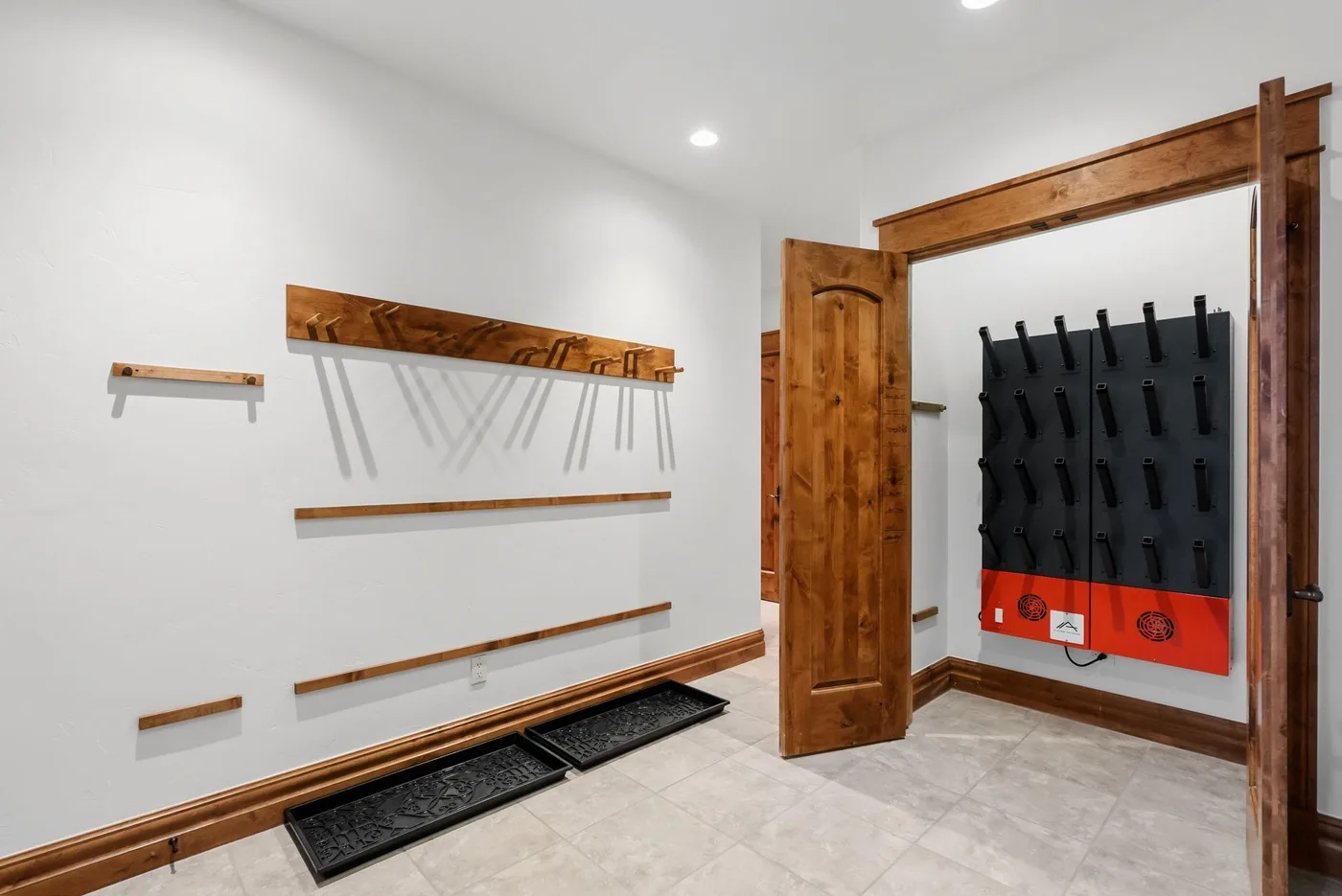 A bright room with wooden wall racks and a large hanging black panel.