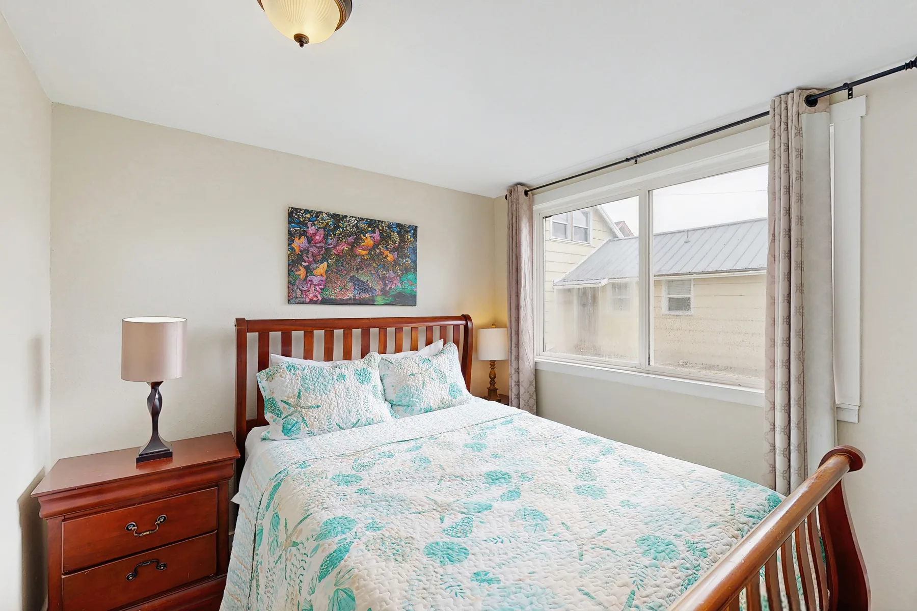A bedroom with a wooden bed and a large window.