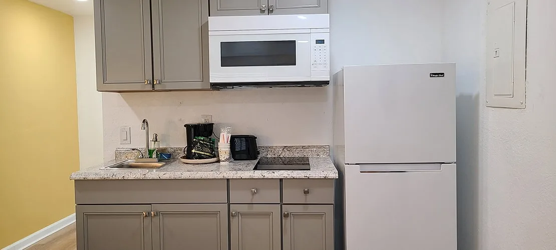 Habitación con dos camas queen y cocina pequeña