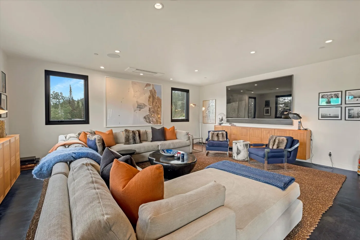 A bright living room with sectional seating, a coffee table, and framed artwork.