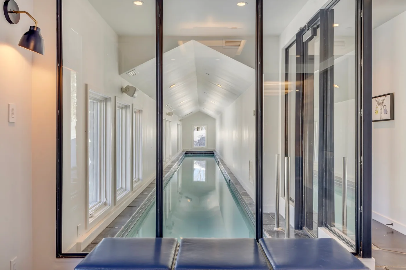 A narrow indoor pool runs beneath a peaked glass ceiling.