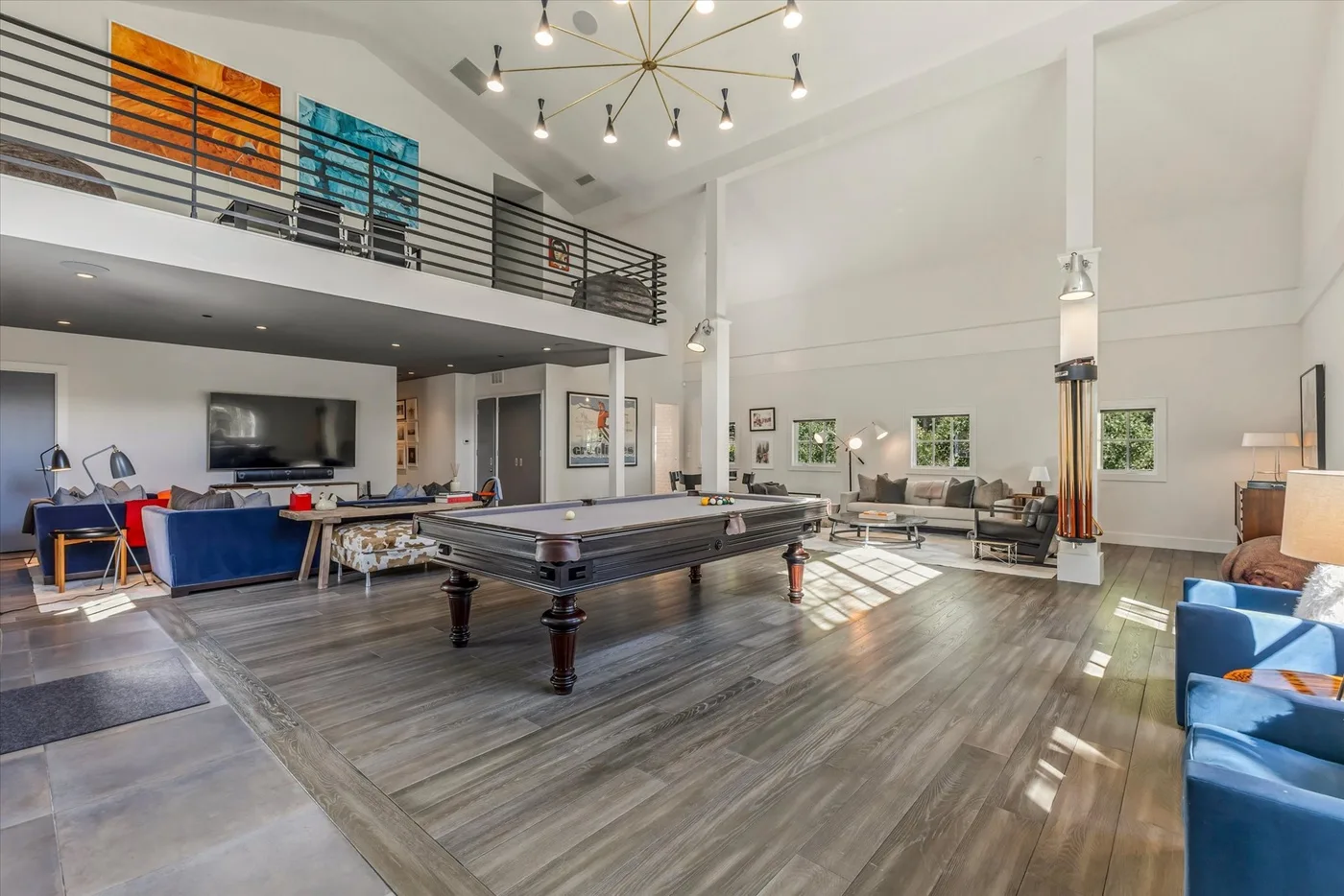 A spacious loft-style living area features a pool table beneath an upper gallery.