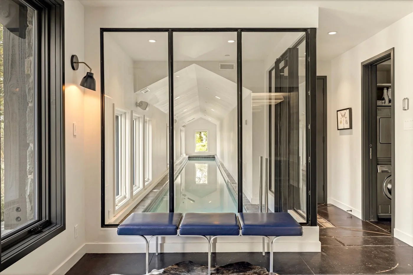 A bright indoor pool extends down a glass-lined hallway.