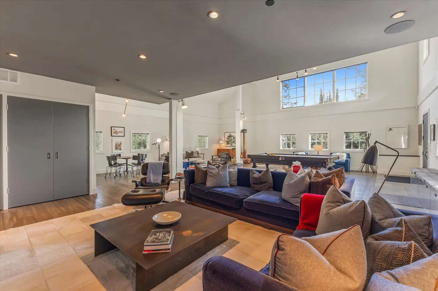 A spacious living room with seating around a low coffee table and dining area beyond.