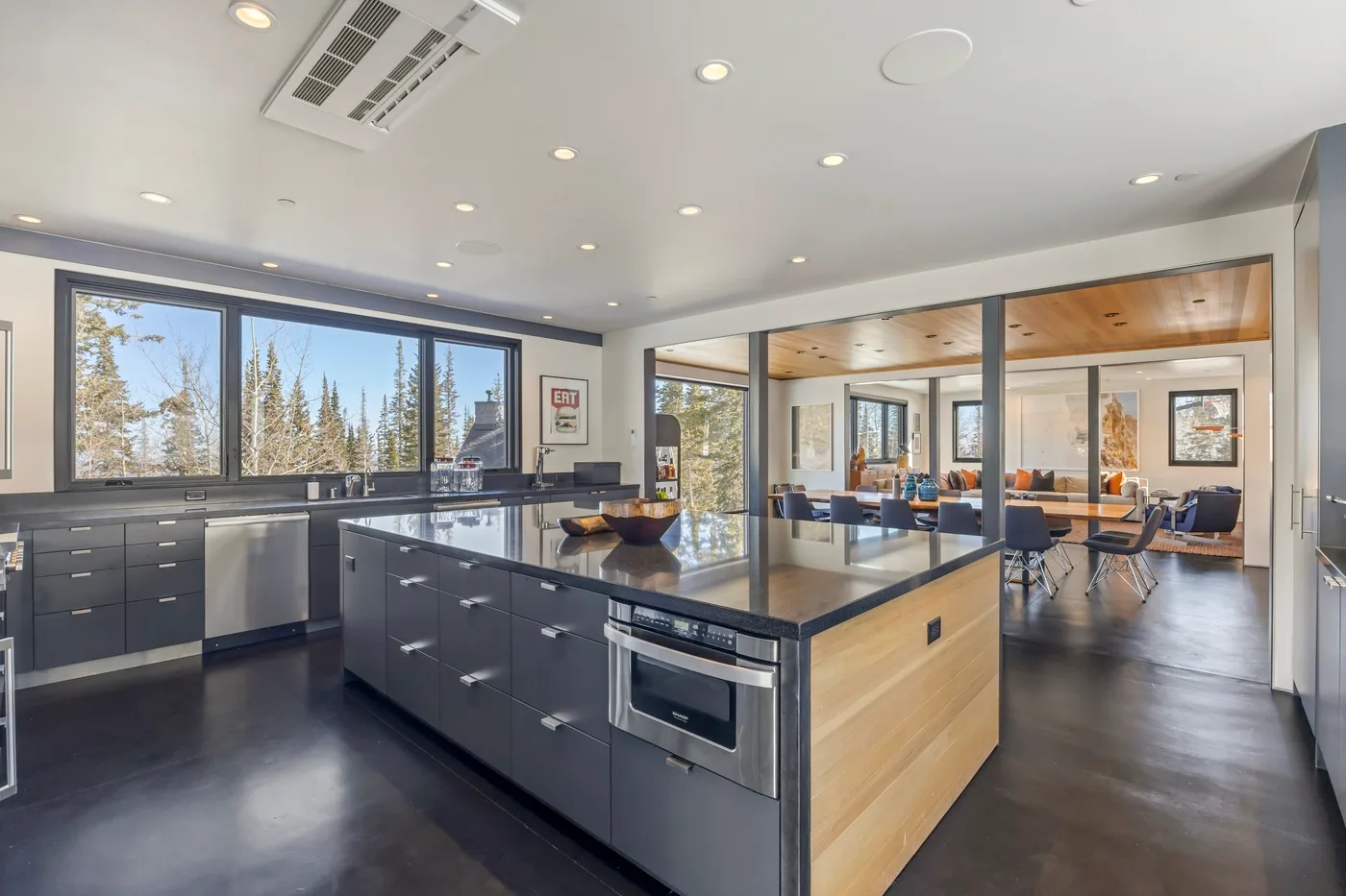 A modern kitchen with a central island opens onto a dining area.