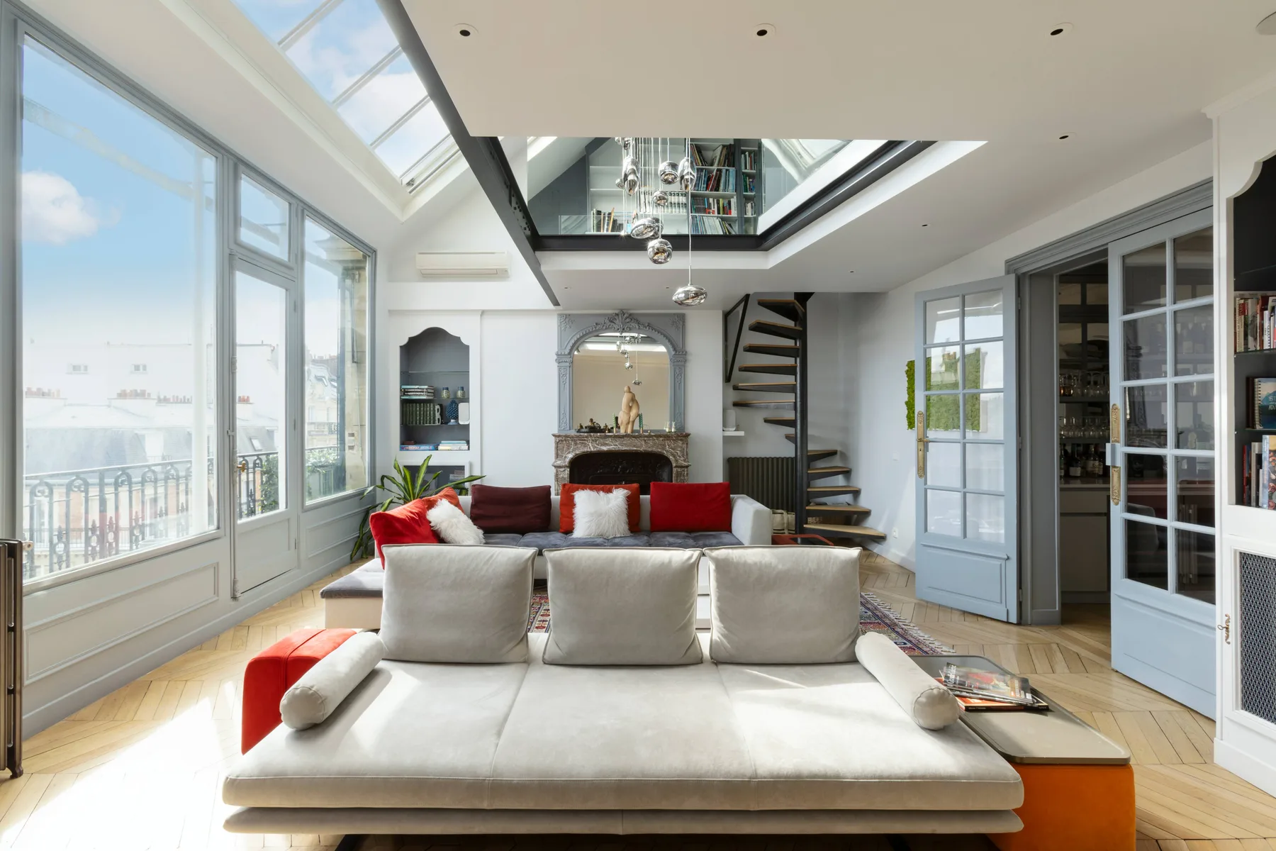 A bright living room with skylights and a large white seating area.