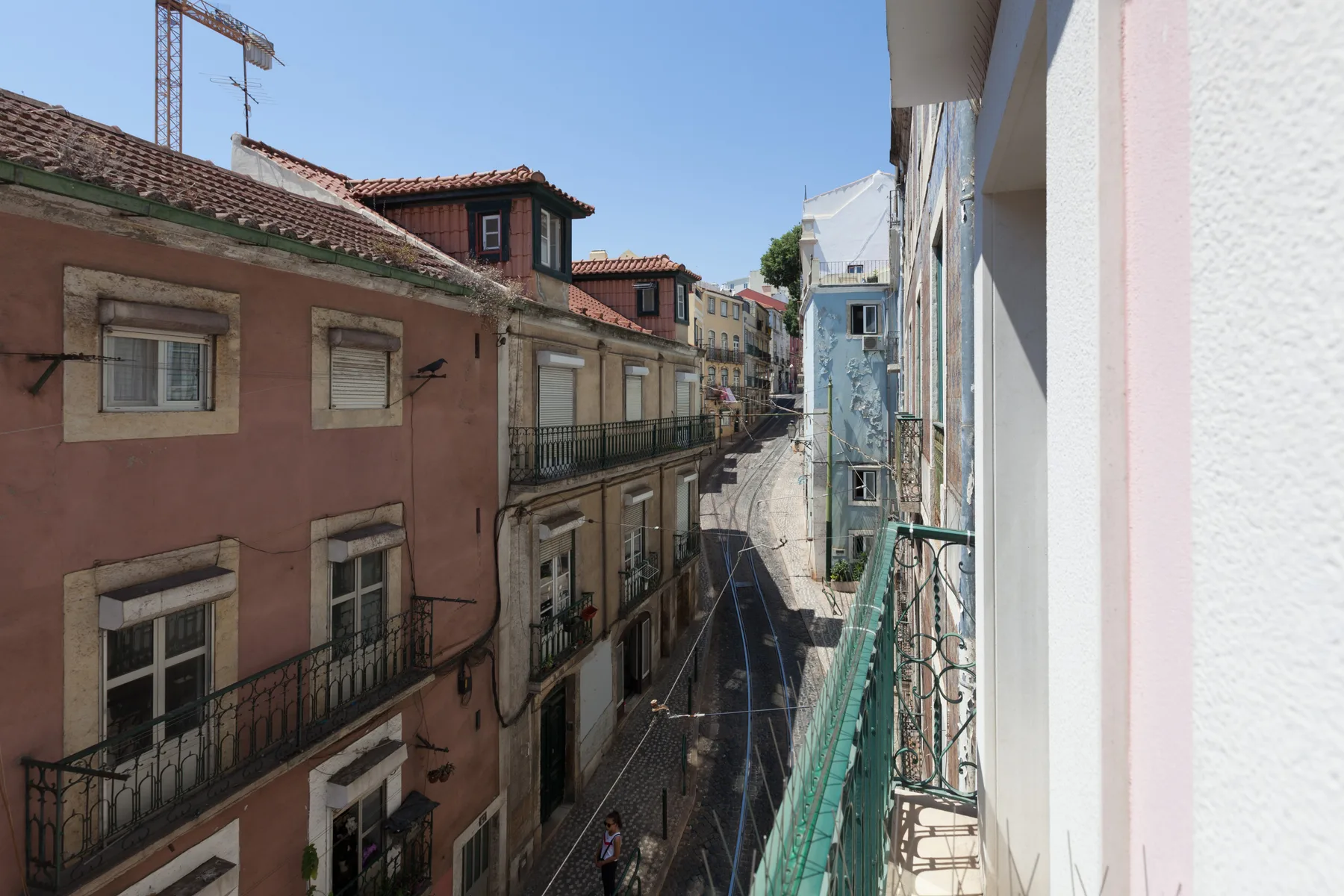 Una calle estrecha pasa entre edificios muy próximos, vista desde un balcón.