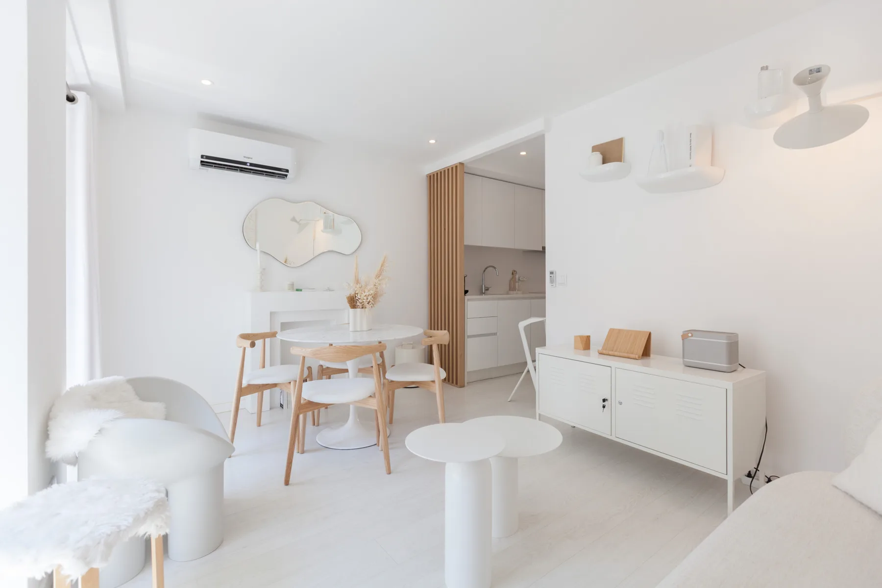 Una luminosa zona de estar y comedor tiene una mesa, asientos y un aparador.