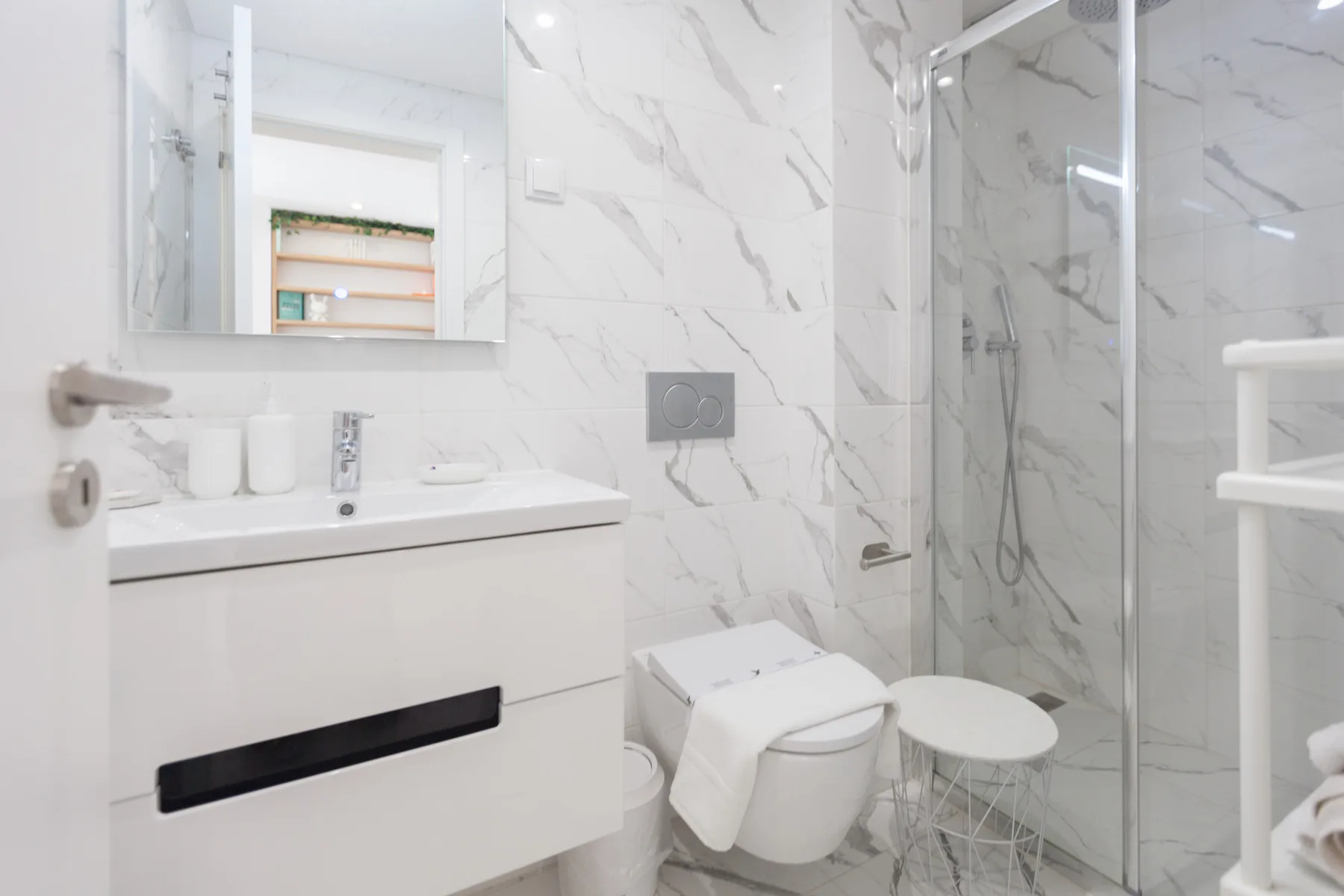 Un baño moderno con lavabo, inodoro y ducha de cristal.