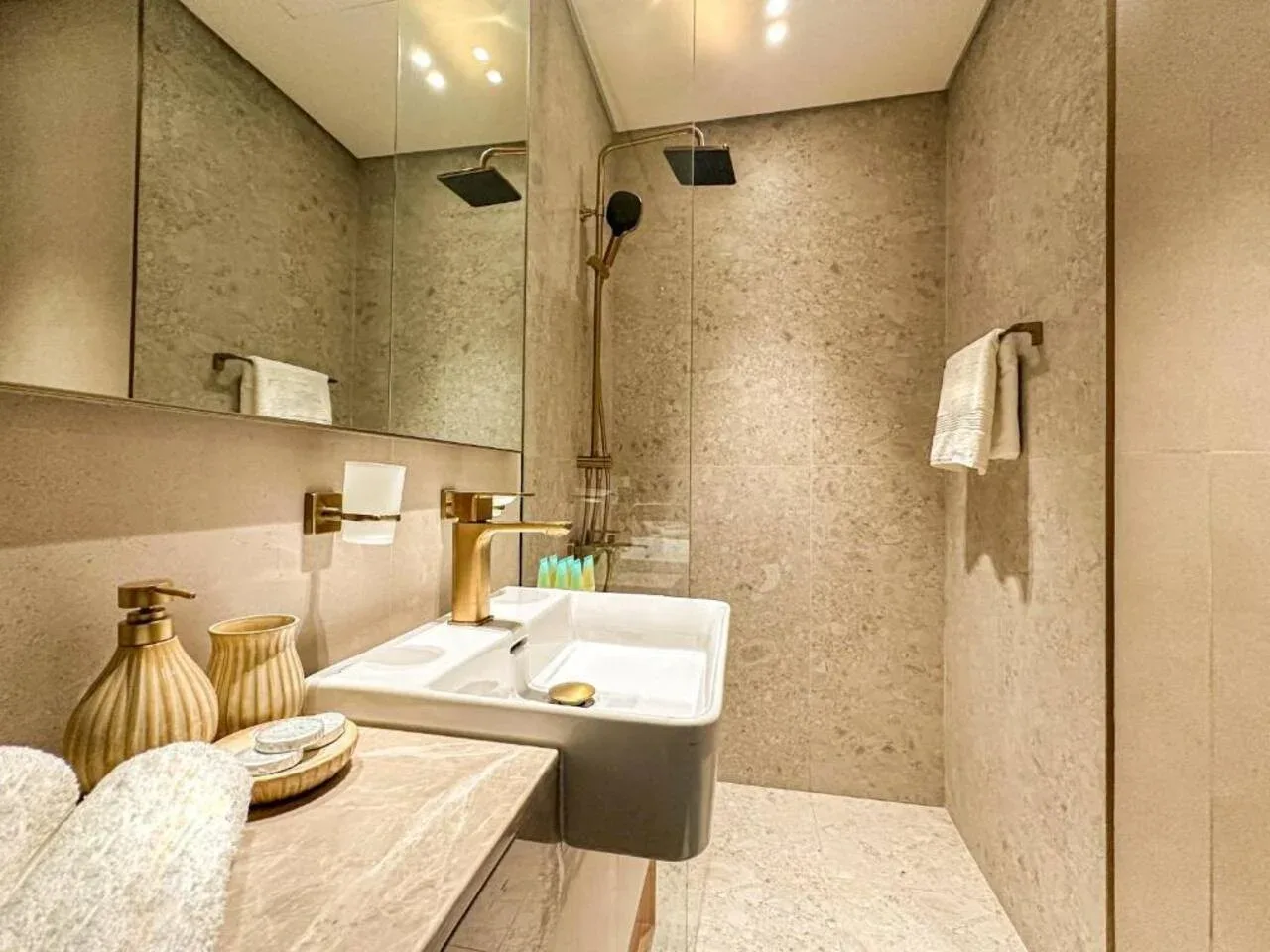 A bathroom vanity with a sink, wall mirror, and shower fixtures.