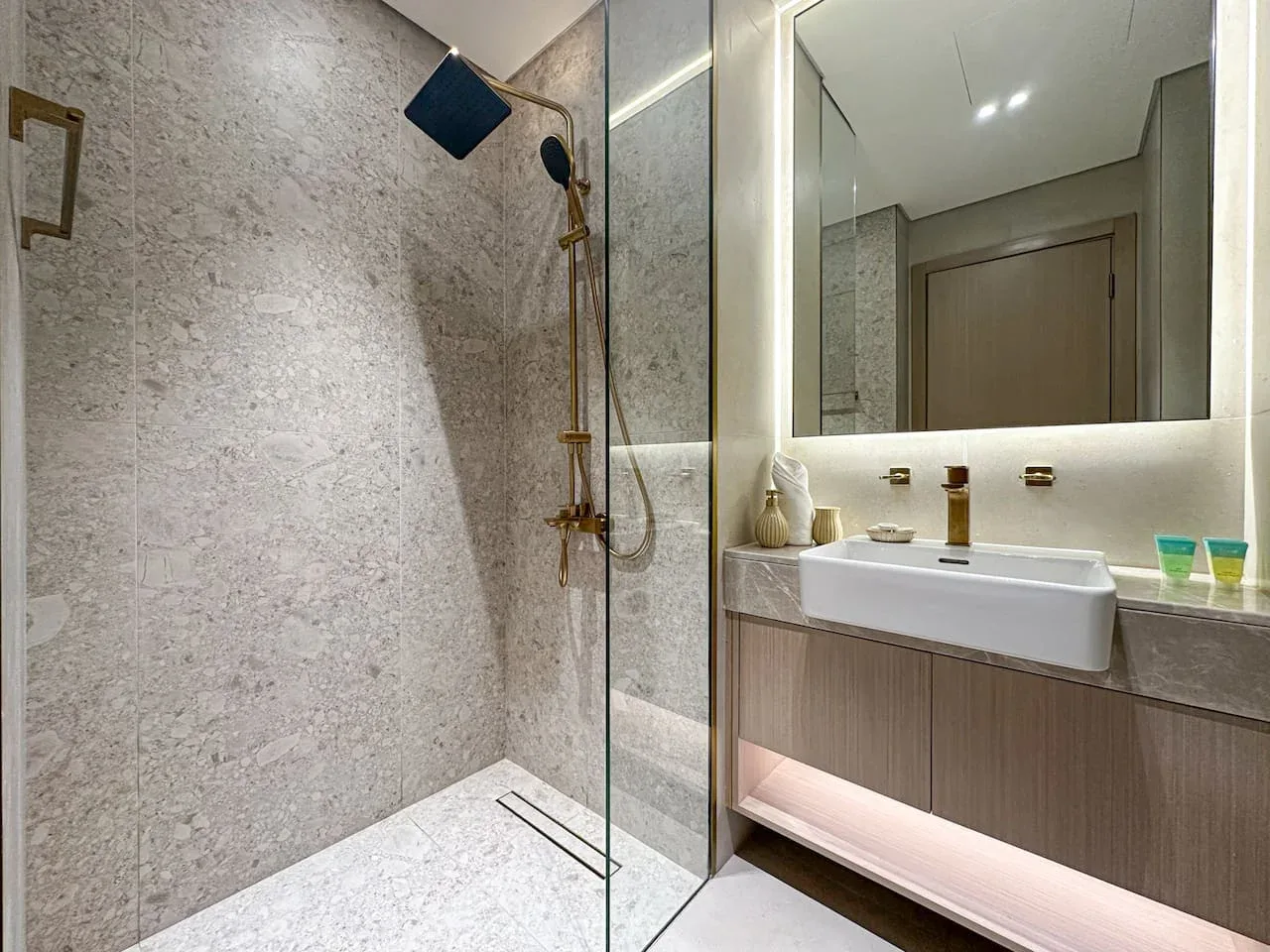 A modern bathroom with a glass shower and a wide vanity.