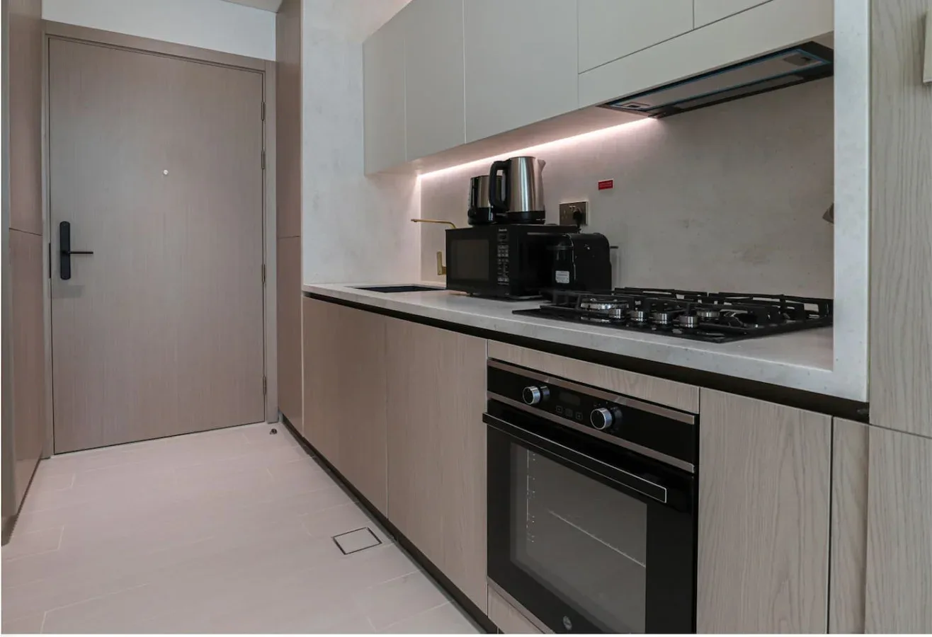 A modern kitchen with white cabinetry, a cooktop, and a built-in oven.