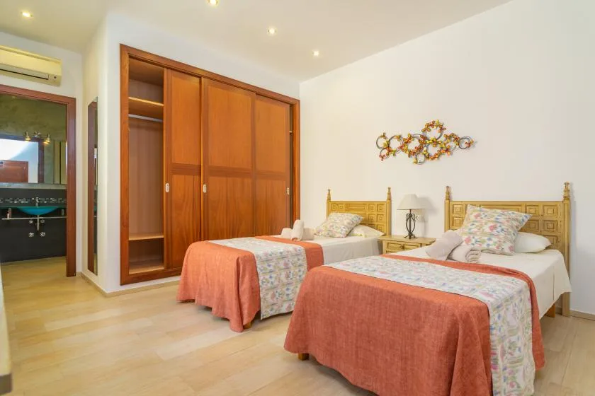 Un dormitorio con dos camas y un gran armario de madera.