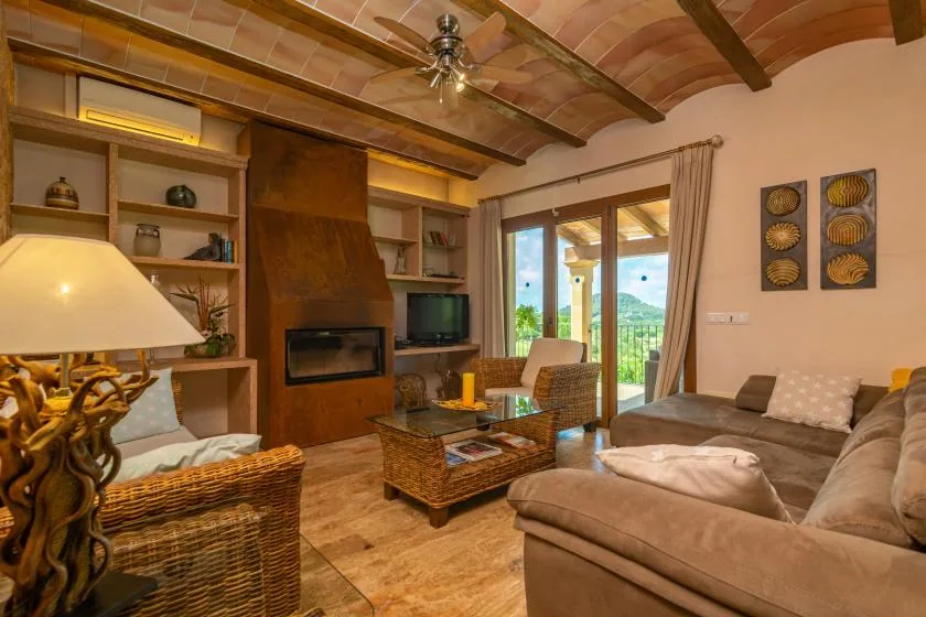 Una sala de estar con asientos, una chimenea y puertas de vidrio que dan a un patio.