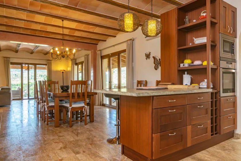 Una cocina abierta y comedor con gabinetes de madera y una mesa de comedor.