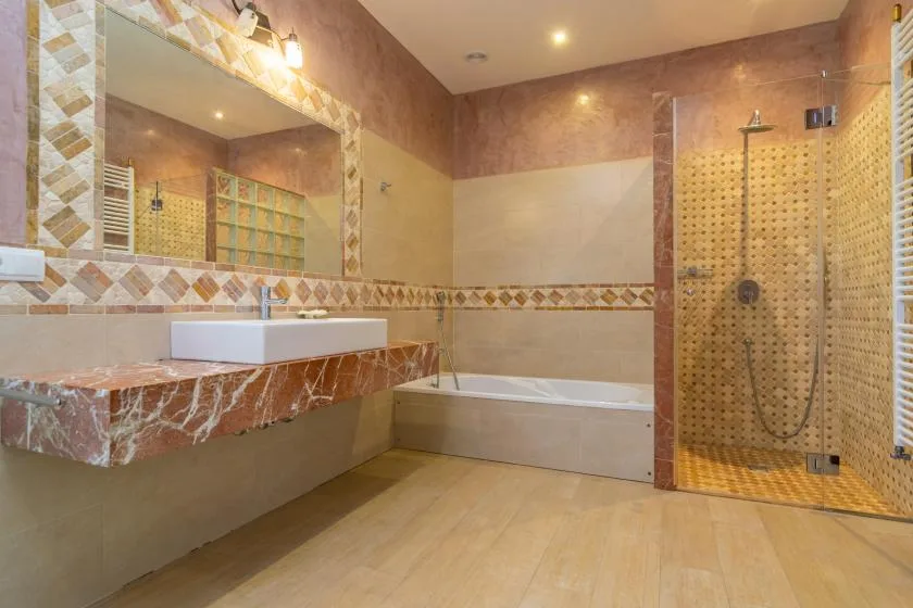 Un baño con lavabo, bañera y ducha con mampara de vidrio.