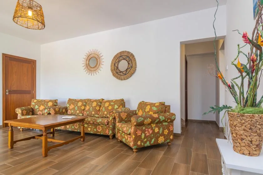 Una sala de estar con asientos estampados y una mesa de centro de madera.