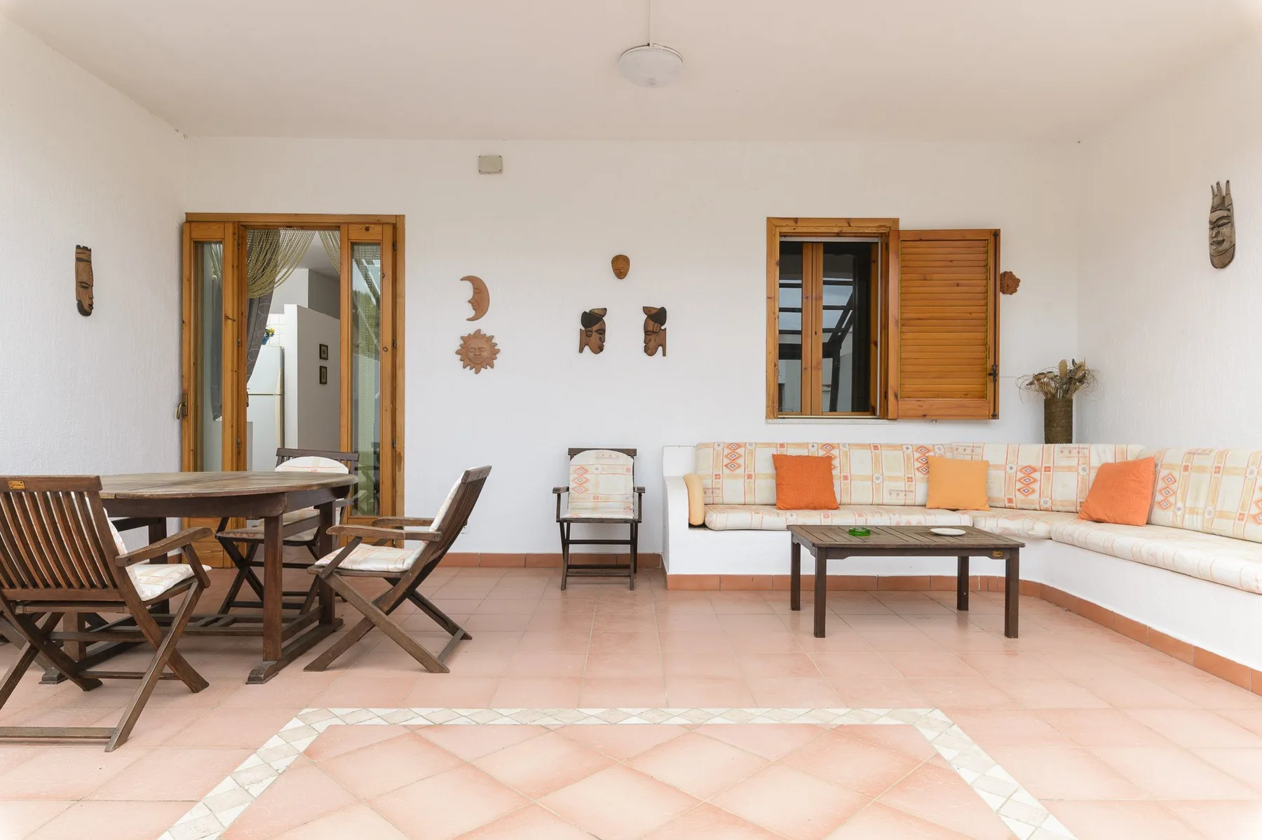 A bright sitting room with a dining table and cushioned seating along the wall.