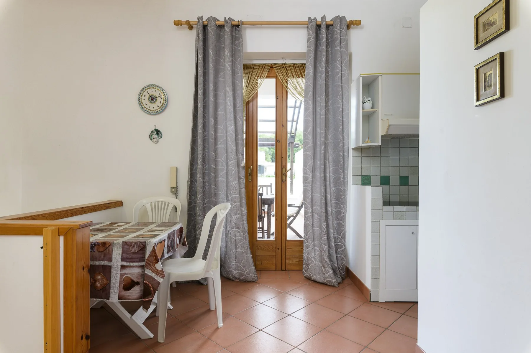 A dining area with a table and chairs beside a curtained glass door.