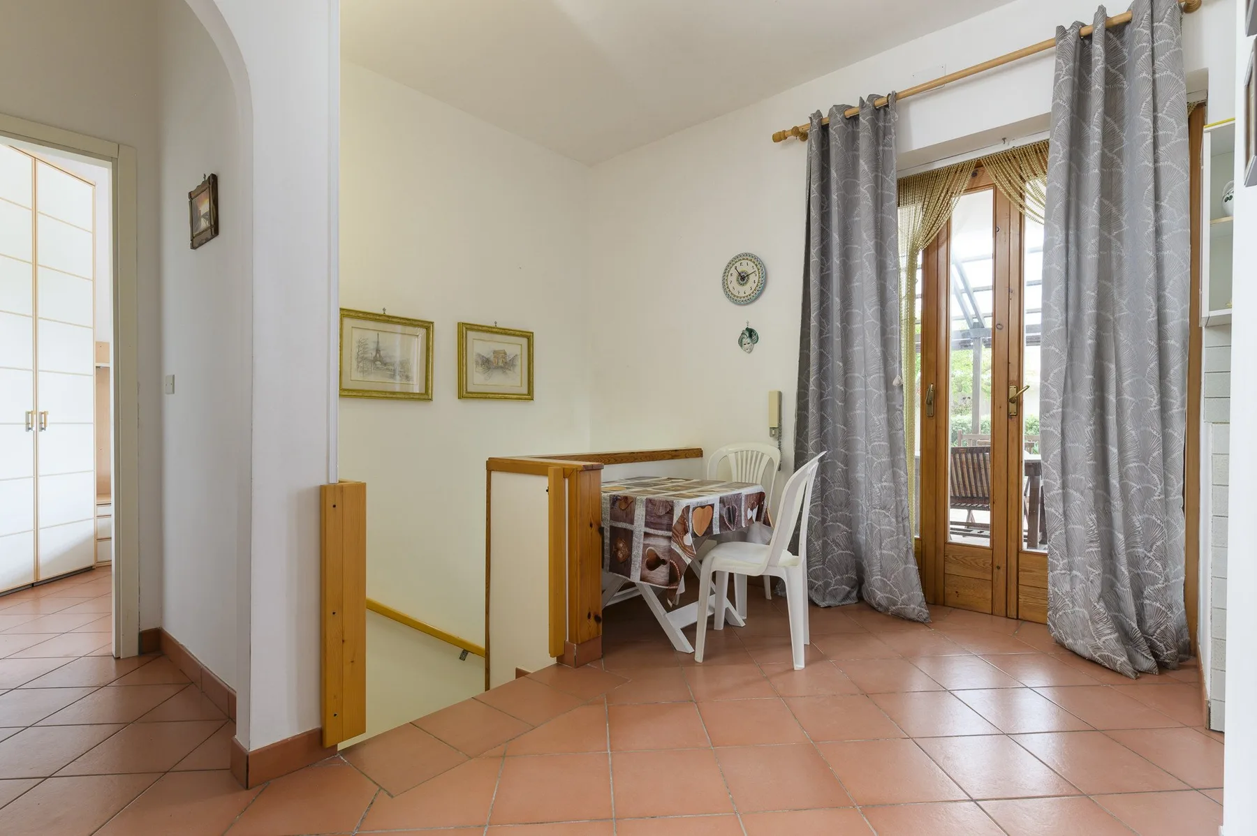 A dining area with a table and chairs beside glass doors opening onto a balcony.