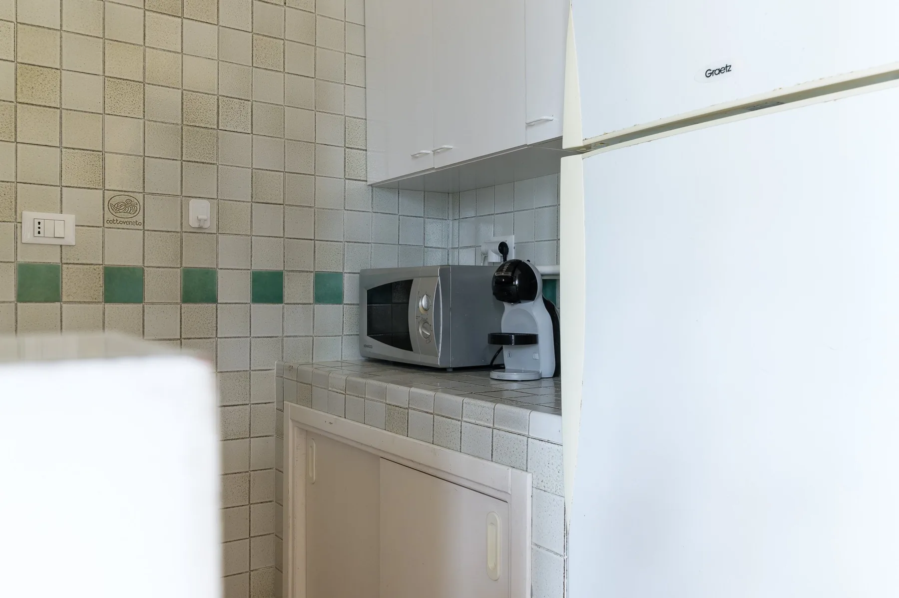A compact kitchen area with a microwave and coffee maker on the counter.