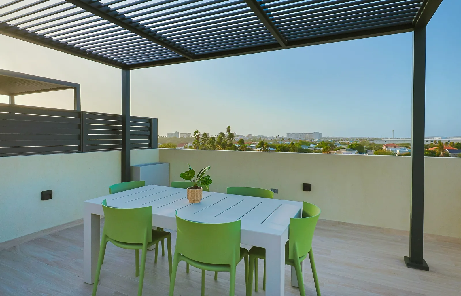Gather around the outdoor dining table on the rooftop terrace, where shaded seating and open views create the perfect setting for al fresco meals and relaxing moments.