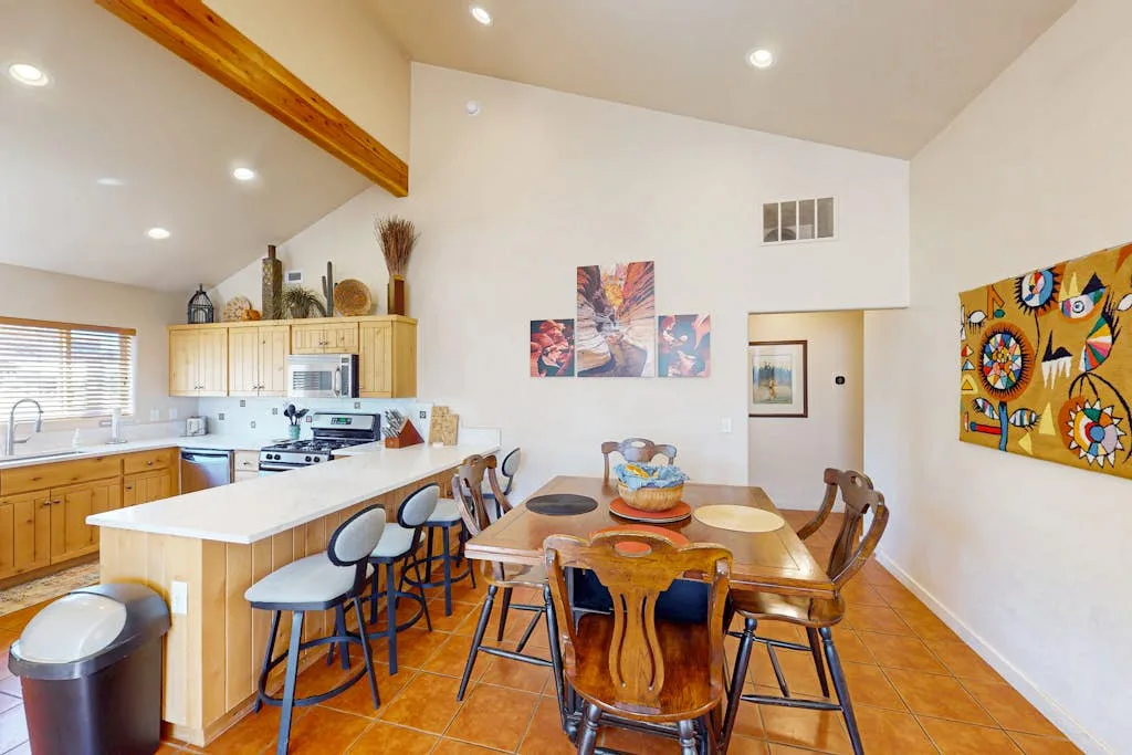 A bright kitchen and dining area with a long table and a central island.