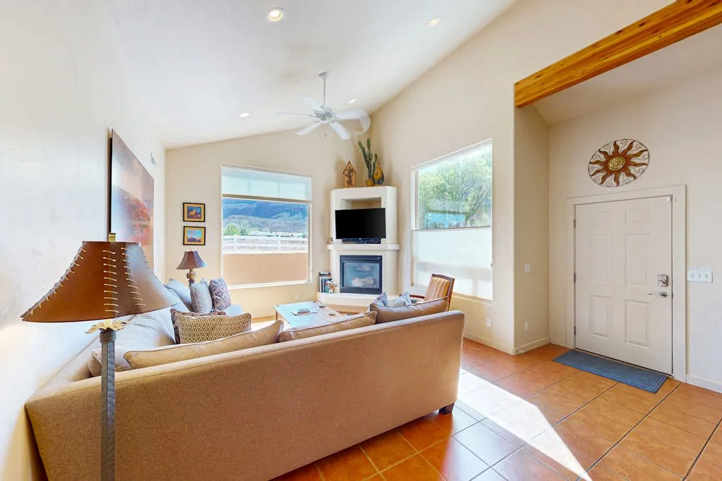 Una sala luminosa con asientos frente a un televisor y una chimenea.