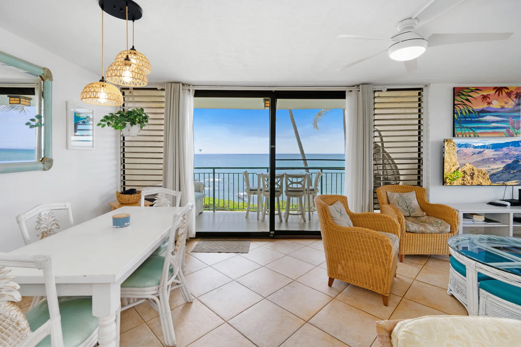 A bright living and dining area opens onto a balcony with ocean views.