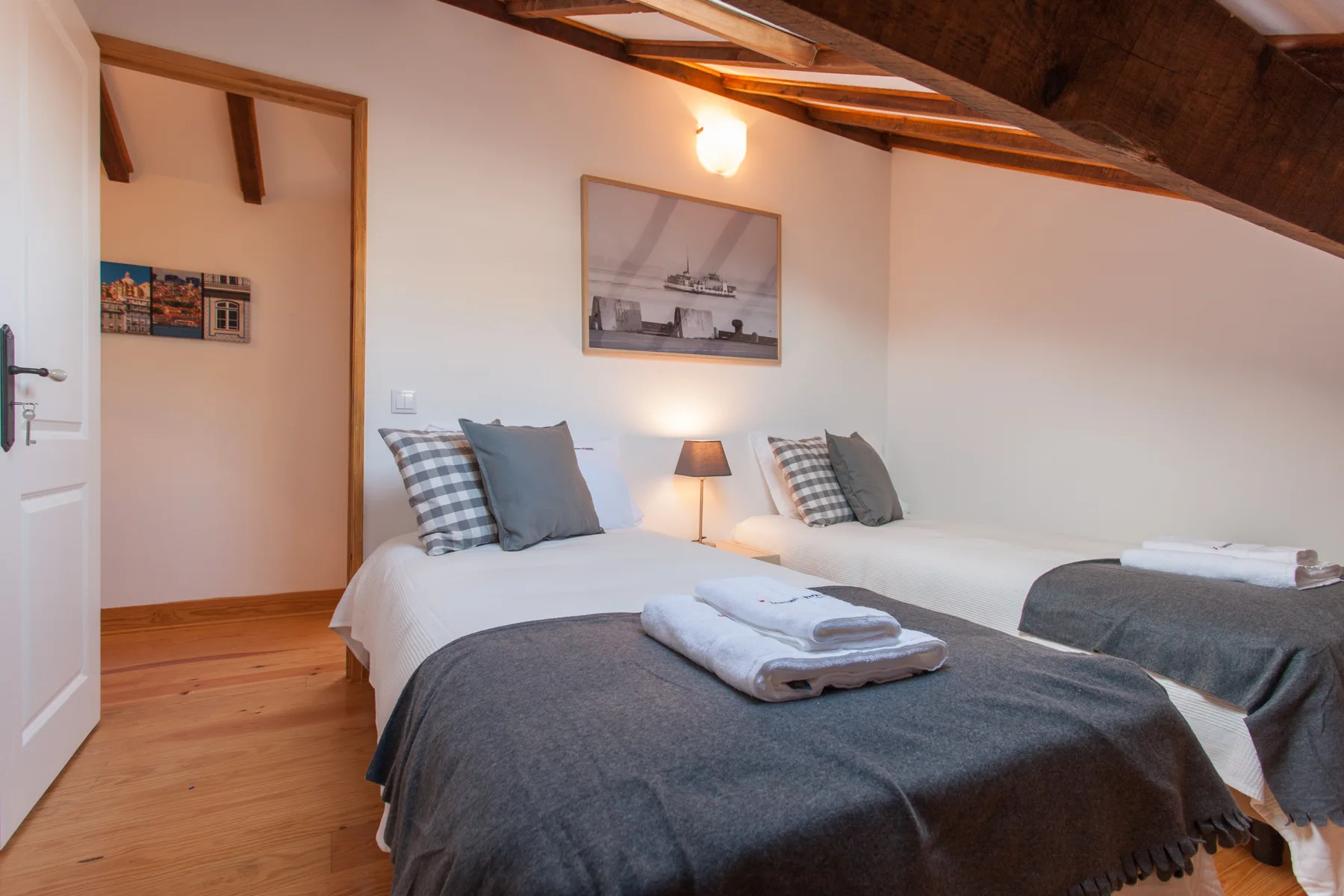 A bedroom with two beds and folded towels on the bedding.