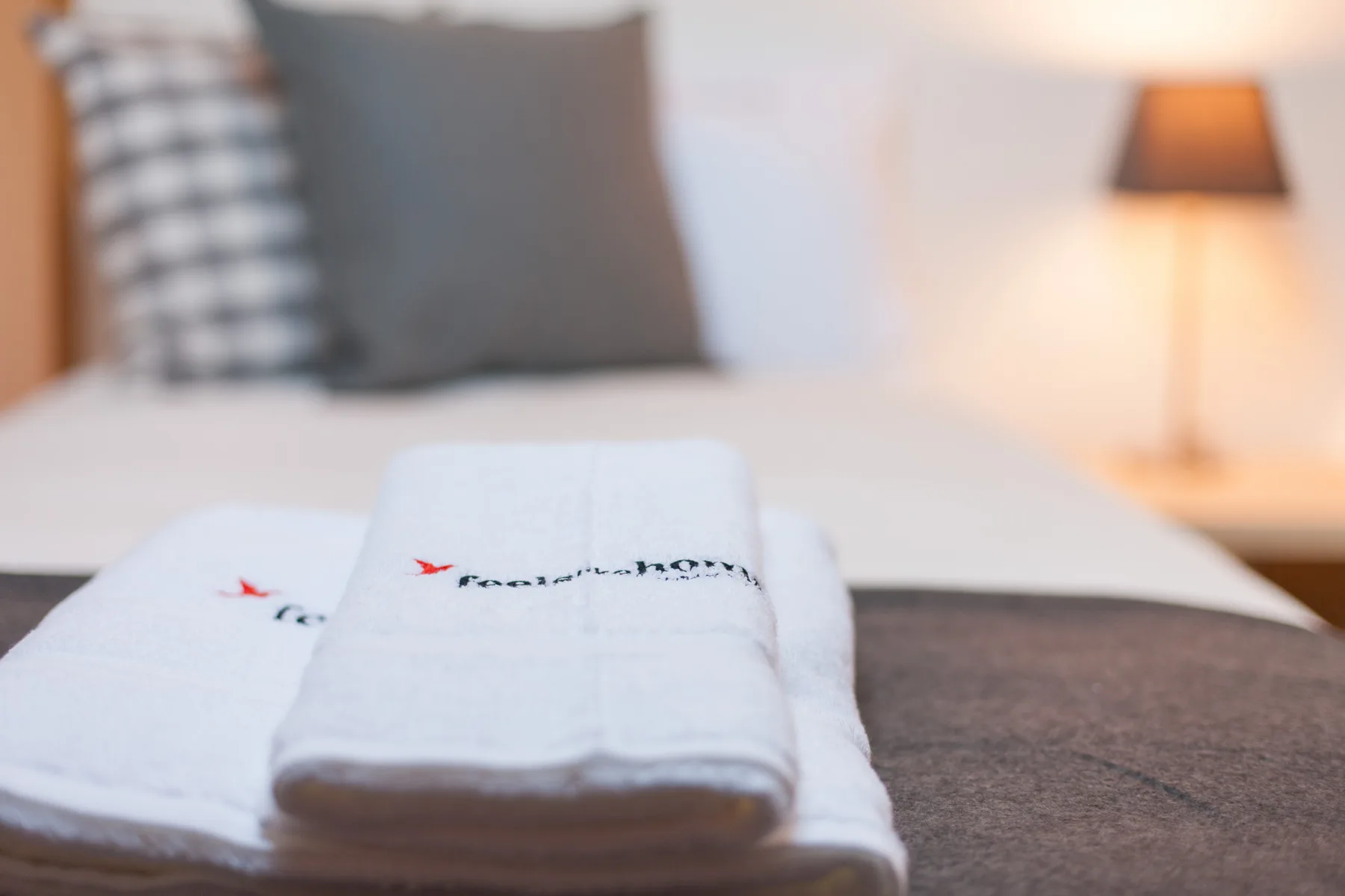A bedroom with folded white towels arranged on the bed.