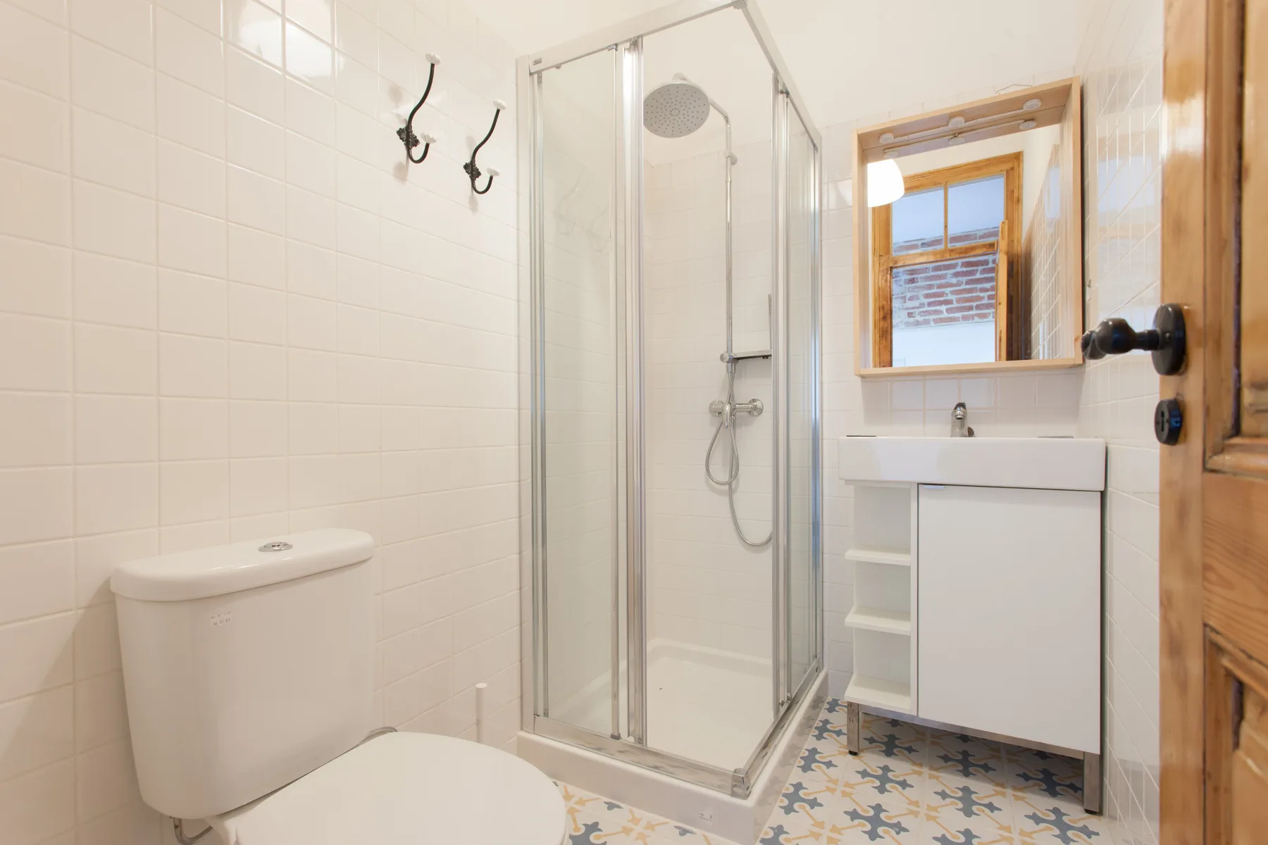 A tiled bathroom with a shower, toilet, and vanity.
