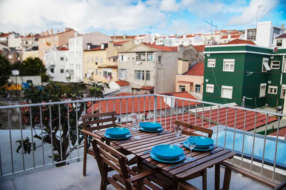 A rooftop terrace dining area overlooks nearby city buildings.