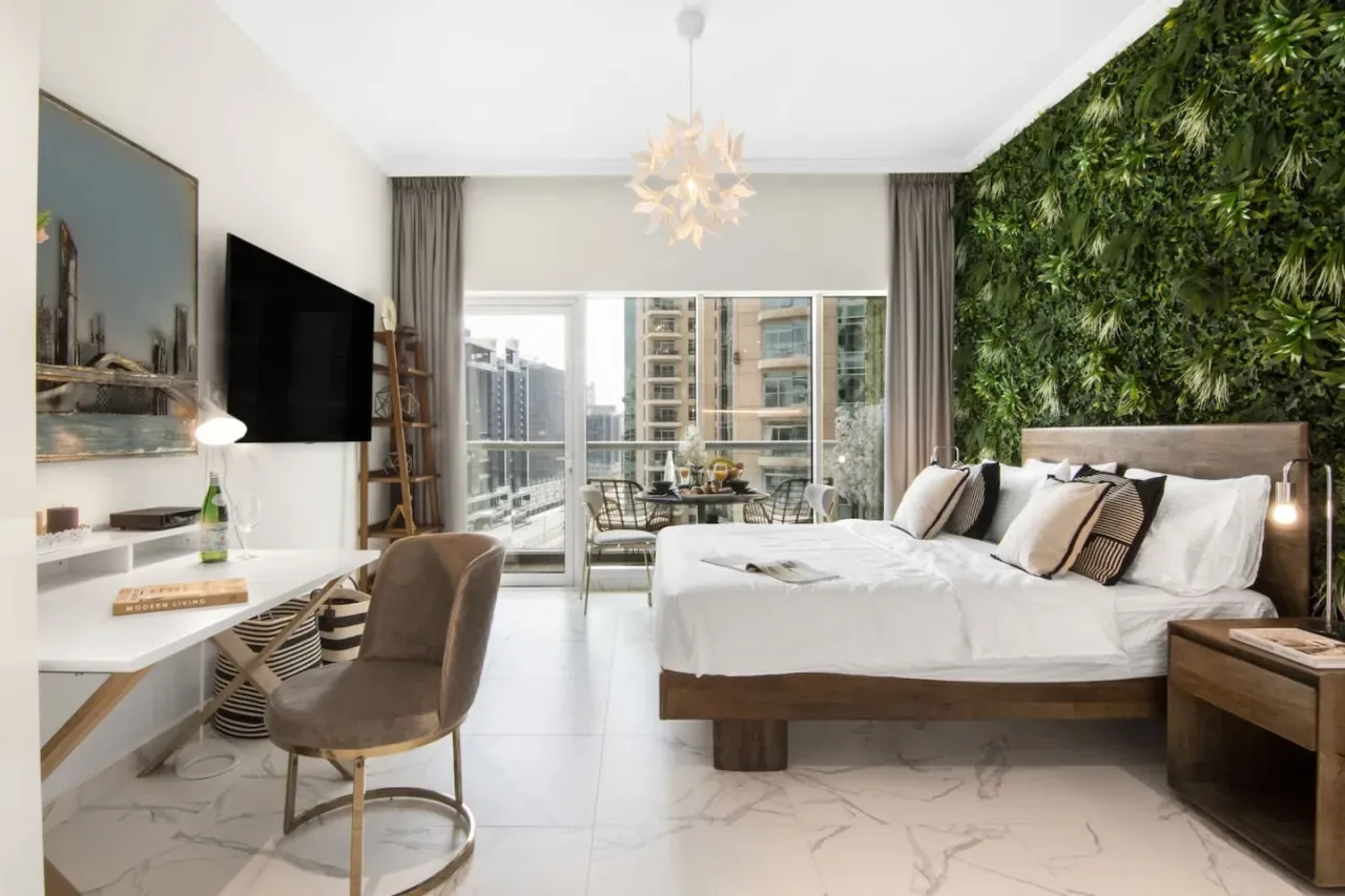 Un dormitorio con una cama grande junto a una pared cubierta de plantas verdes.
