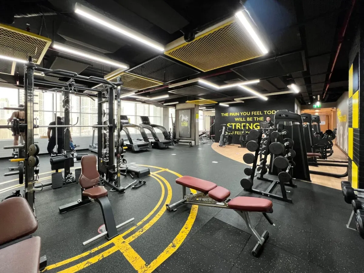 A gym workout area with exercise machines, weight equipment, and benches.