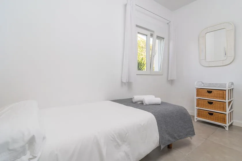 A bright bedroom with a bed and a window.