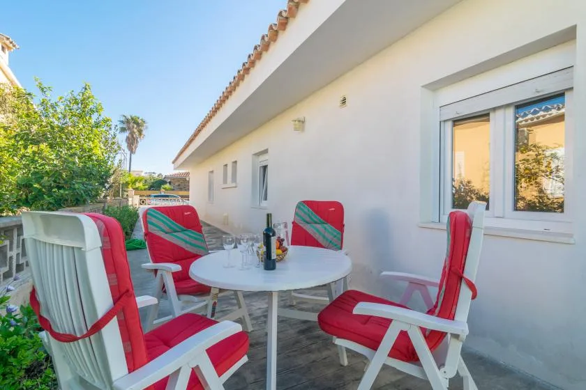 An outdoor patio with red-cushioned seating around a small table.