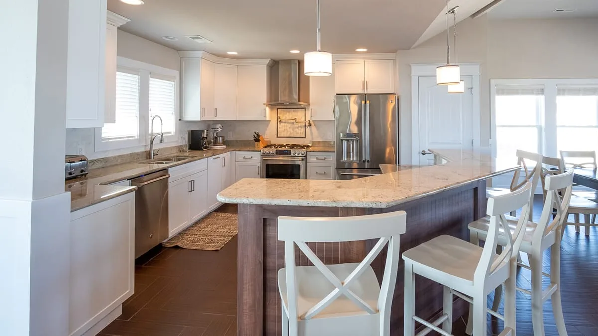 A bright kitchen with a large island and white cabinetry.