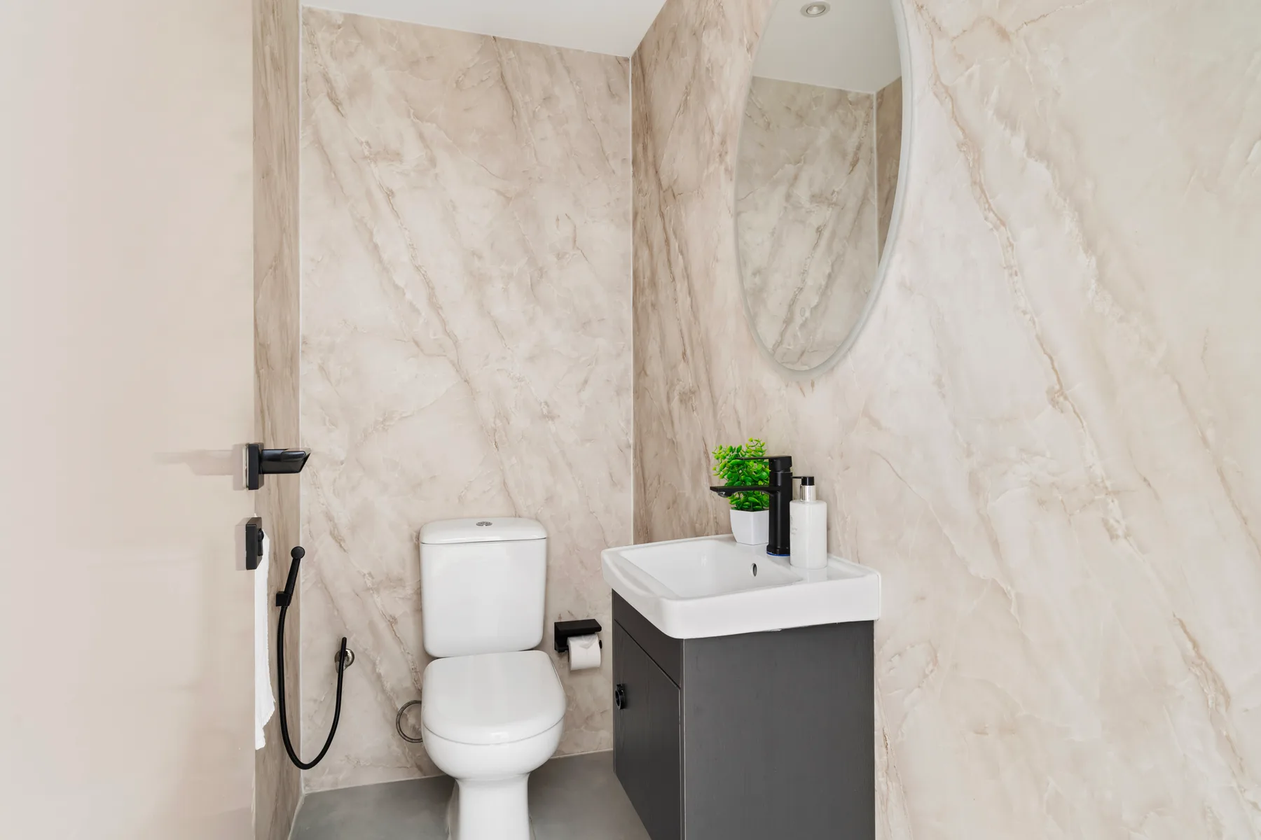 Un baño con inodoro, lavabo y un espejo grande en la pared.