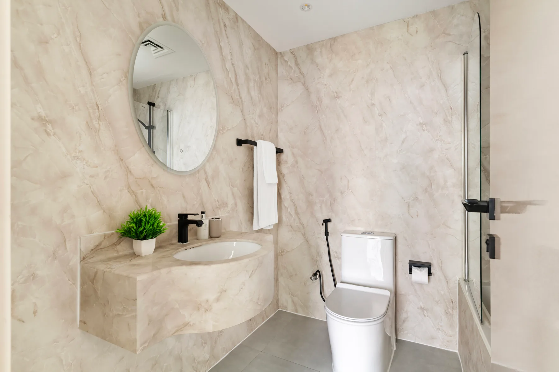 Un baño con lavabo, inodoro y panel de ducha de vidrio.