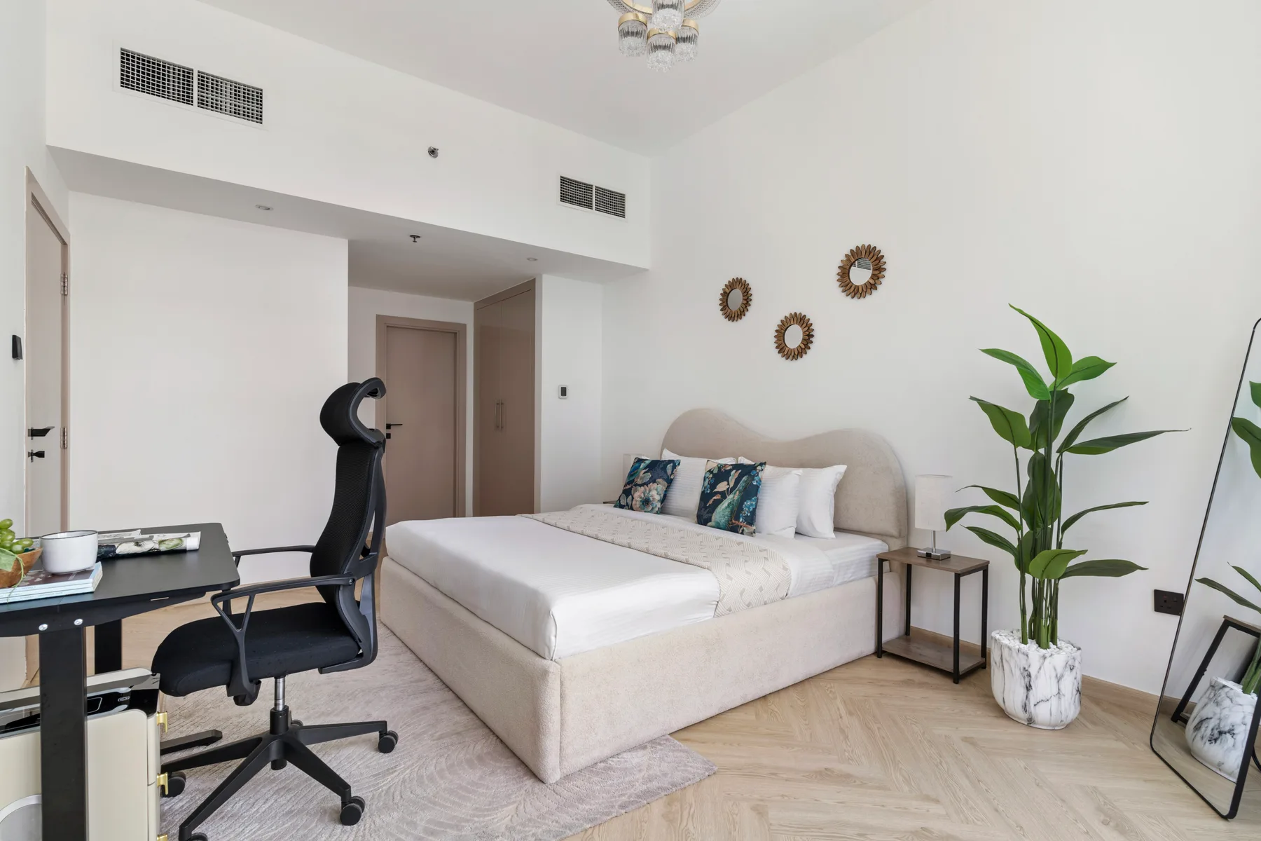 Un dormitorio con una cama, un escritorio y plantas en macetas.