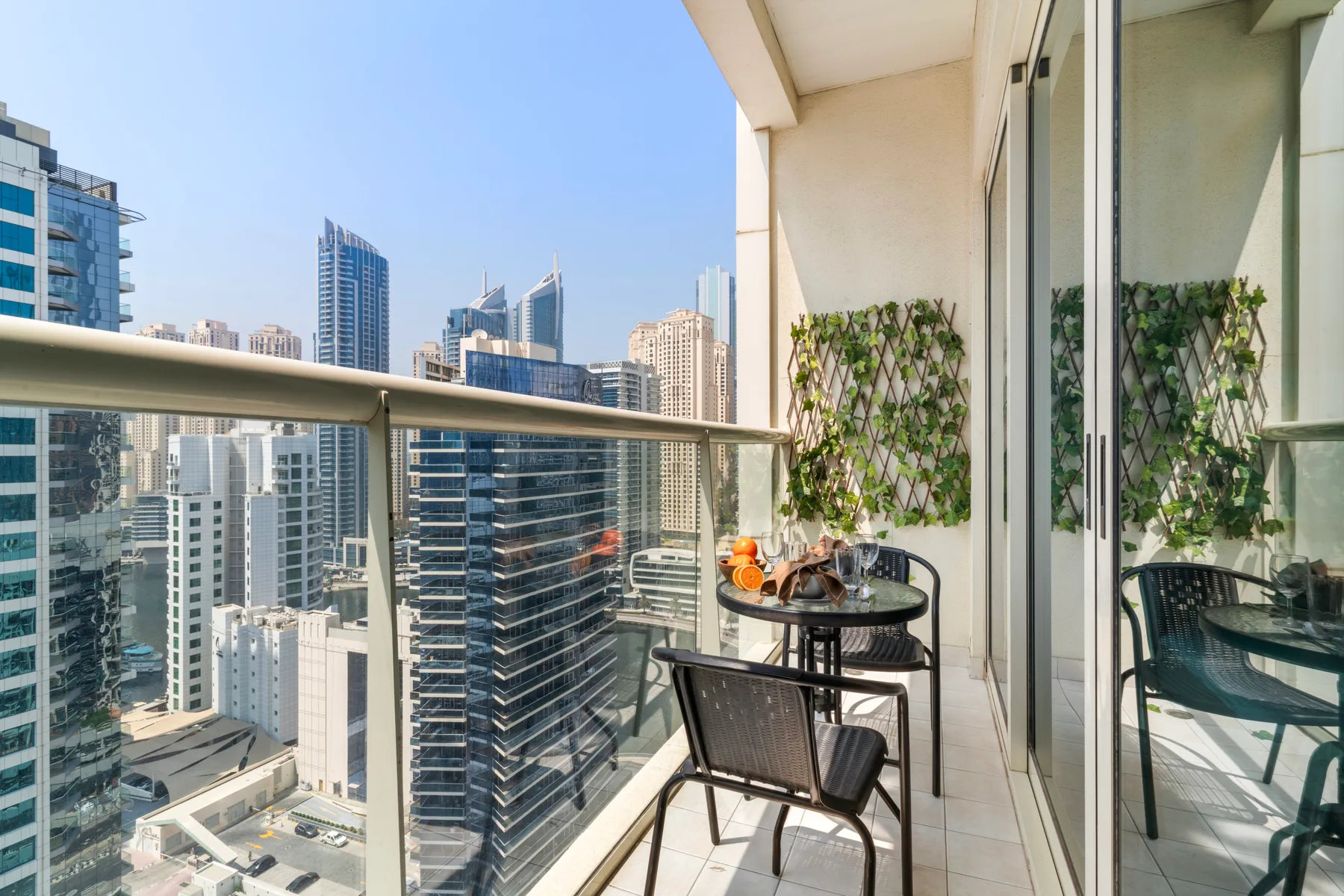 Una zona de estar en el balcón ofrece vistas a varios edificios modernos de gran altura.