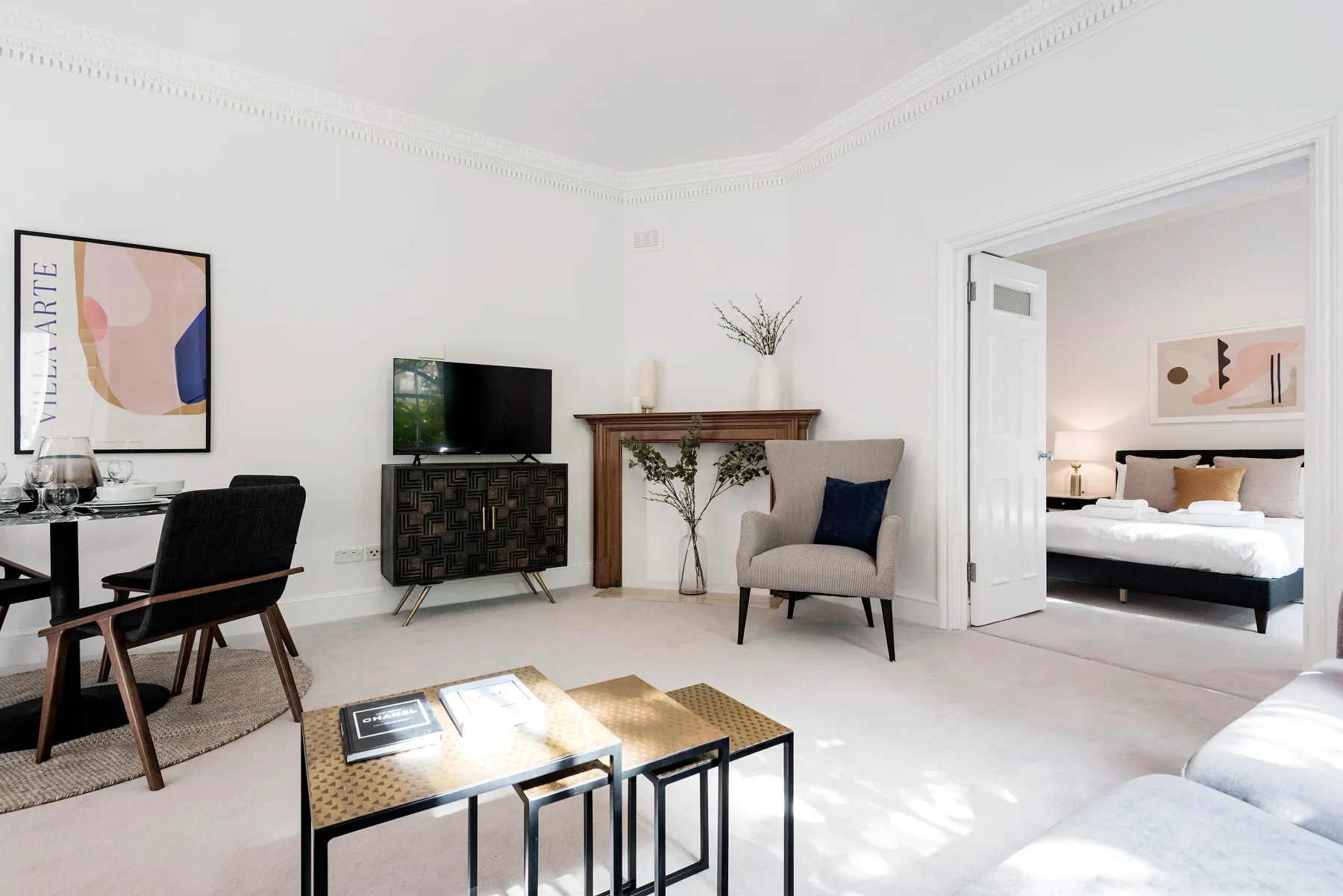 A sitting area with a television and an open doorway to a bedroom.