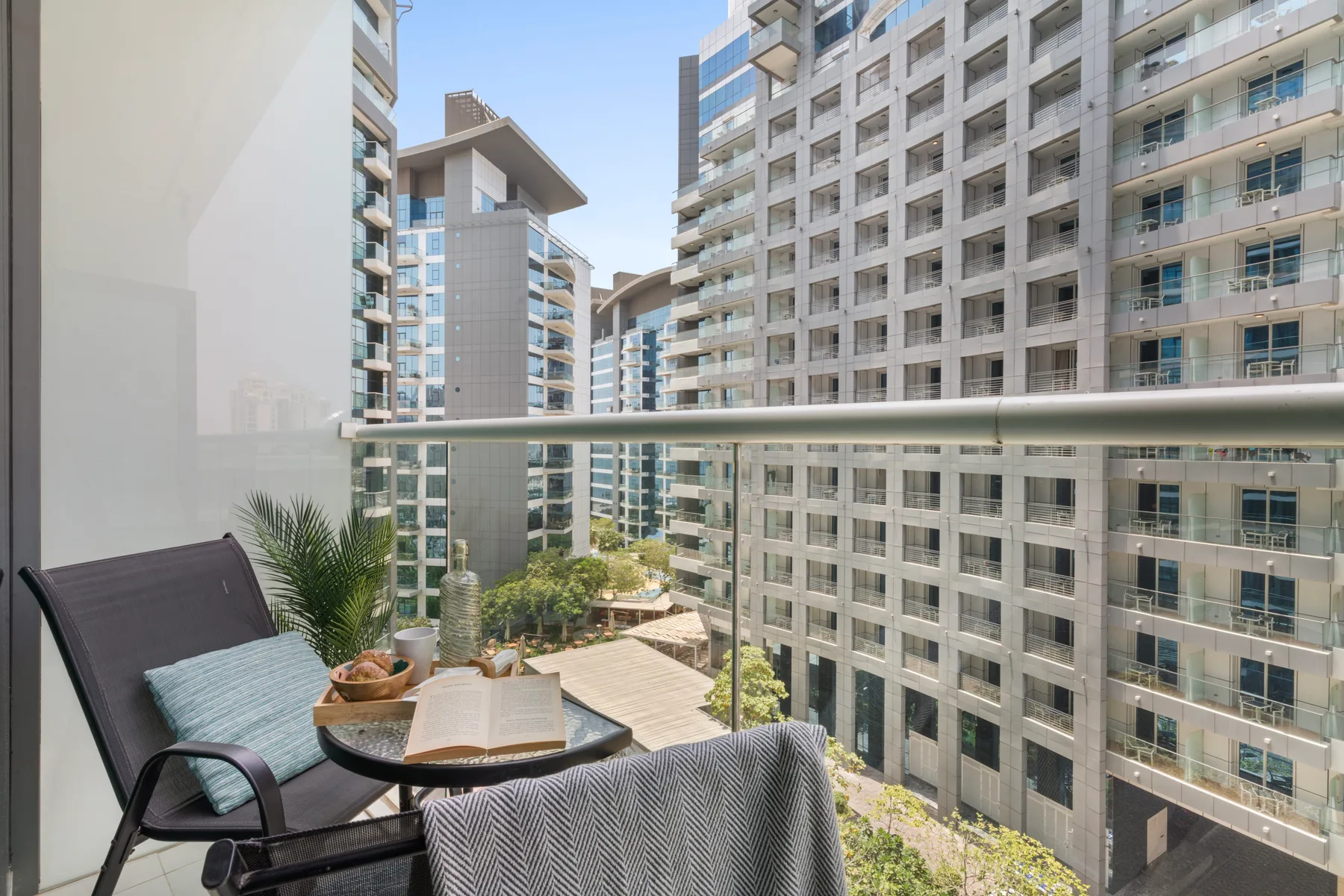 Una zona de estar en un balcón da a un conjunto de edificios de apartamentos modernos.