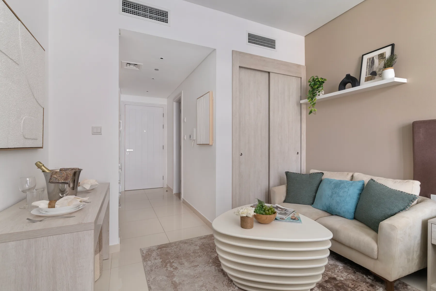 Una sala luminosa con un sofá y una mesa de centro escultural.