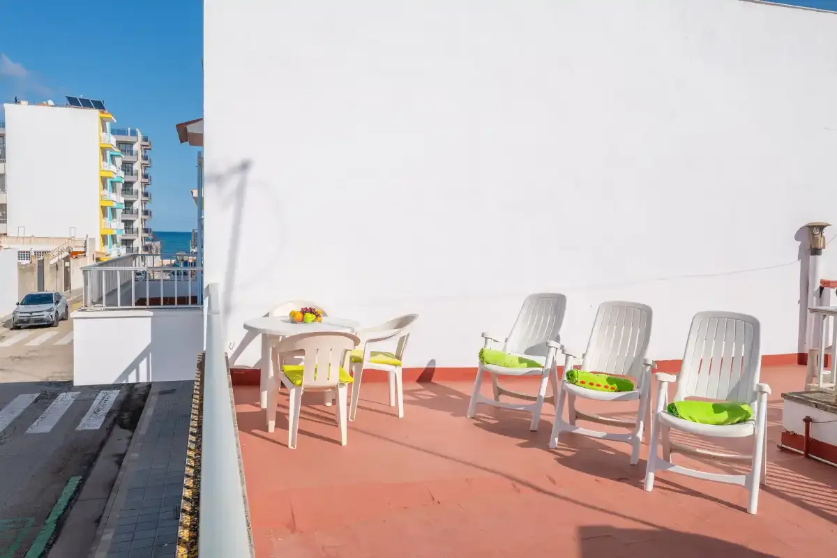 A rooftop terrace with outdoor seating and a small table.