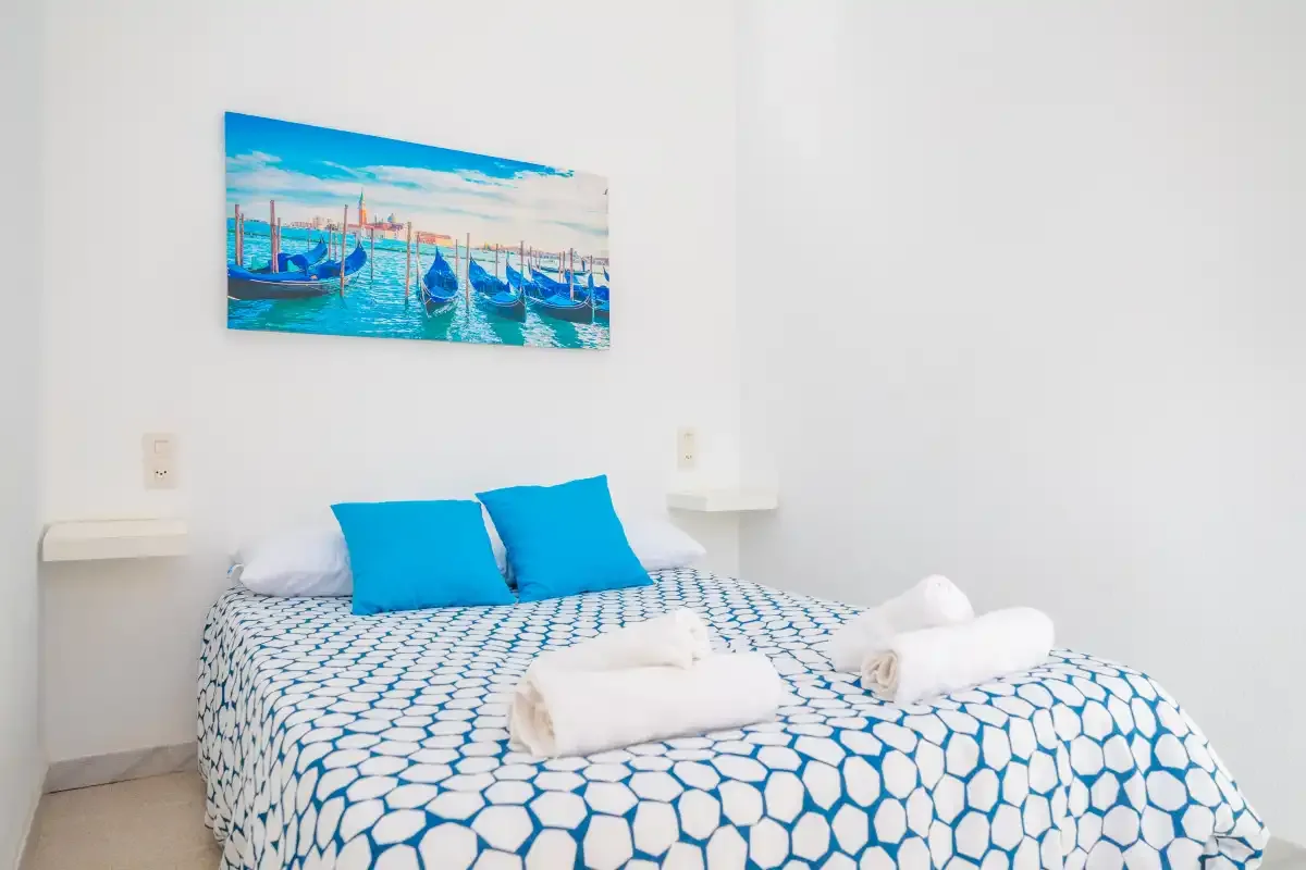 A bedroom with a bed covered in blue-and-white patterned bedding.