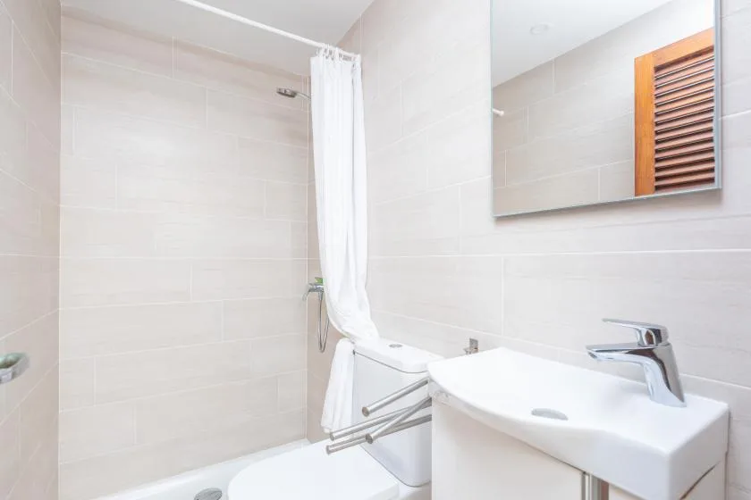A tiled bathroom with a shower curtain and a white sink.